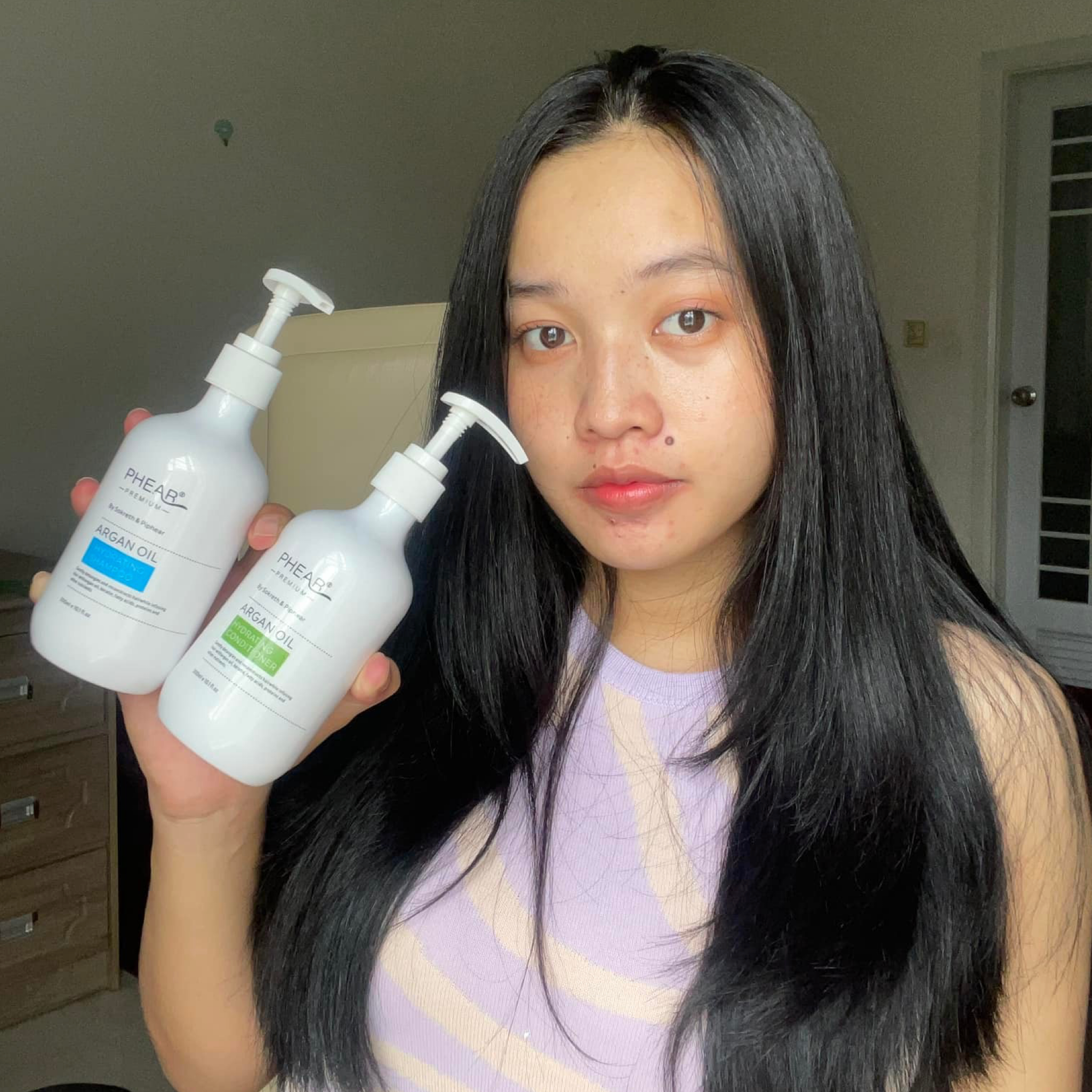  a beautiful woman holding a 2 in 1 set of Hydrating shampoo&condtioner  