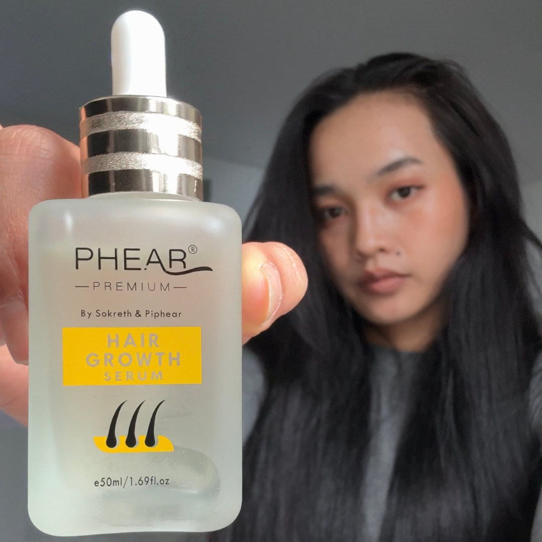 Hair growth serum bottle held by a person with a blurred background