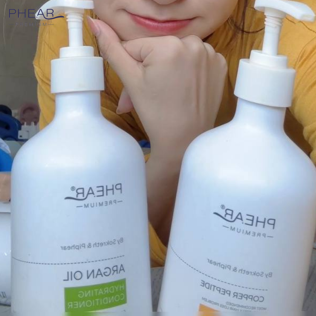 Two white bottles with pump dispensers labeled 'PHEAR' held by a beautiful woman
